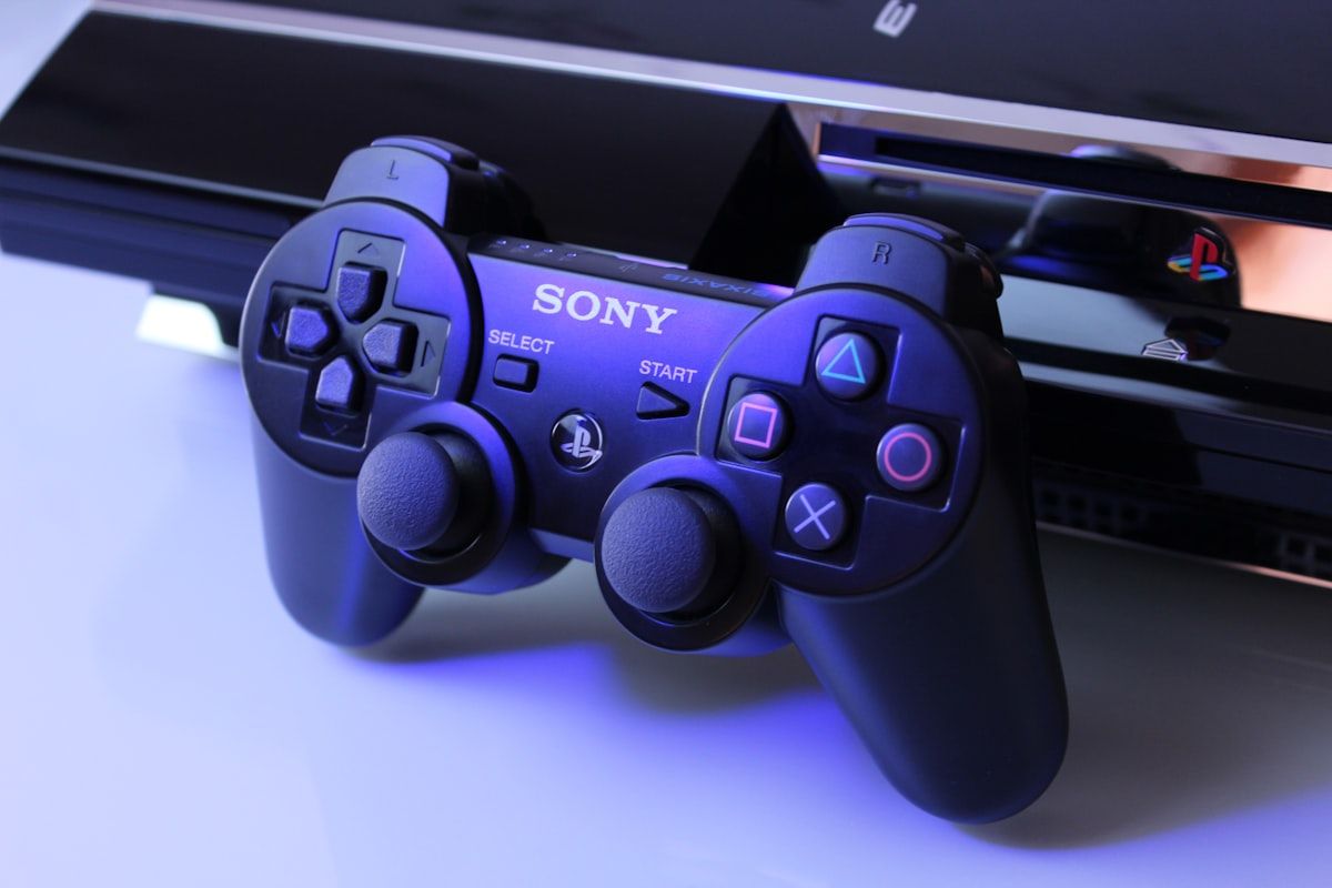 Controle PS2 preto sobre superfície branca para gamers Controle preto da Sony PS2 sobre superfície branca, ideal para gamers e fãs de Rainbow Six Esports