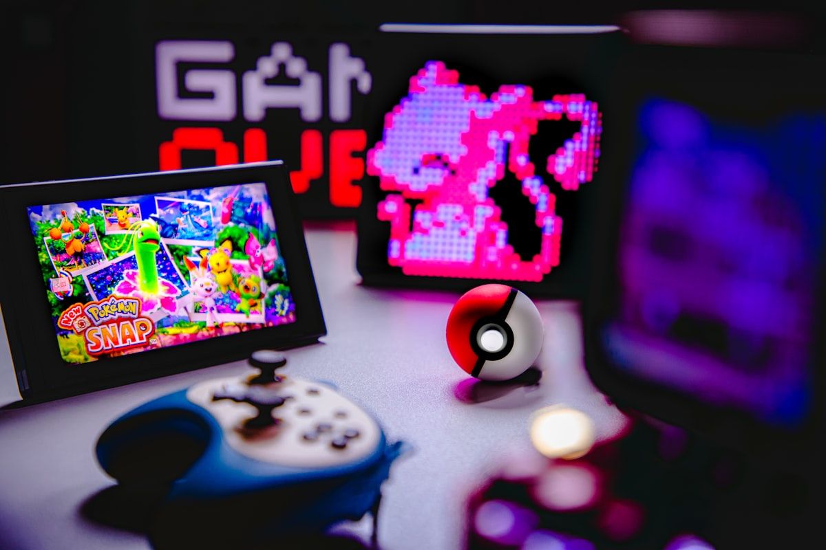 Diversos controles de videogame coloridos dispostos em um fundo neutro, representando a diversidade de consoles