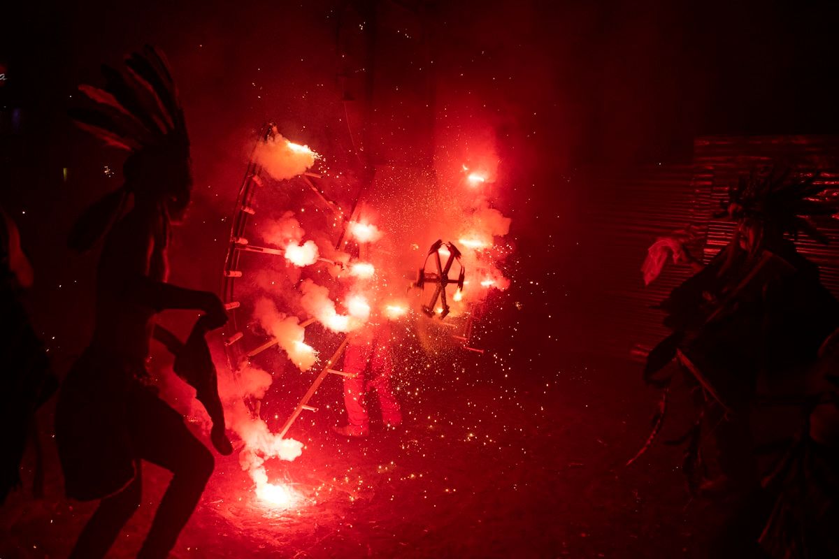 Pessoas admirando fogos de artifício em uma festa Grupo de pessoas assistindo a um espetáculo de fogos de artifício durante uma celebração
