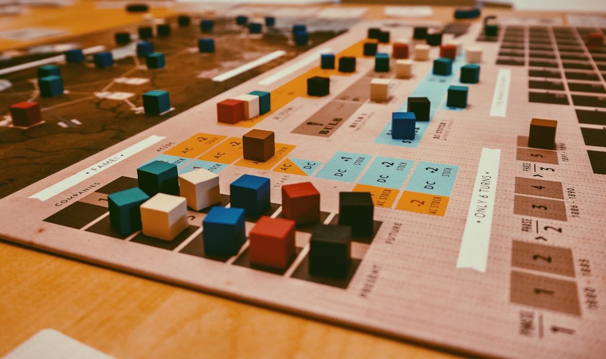 Peças de madeira coloridas em tabuleiro de jogo Peças de madeira coloridas dispostas em um tabuleiro de jogo, prontas para serem usadas em uma partida estratégica
