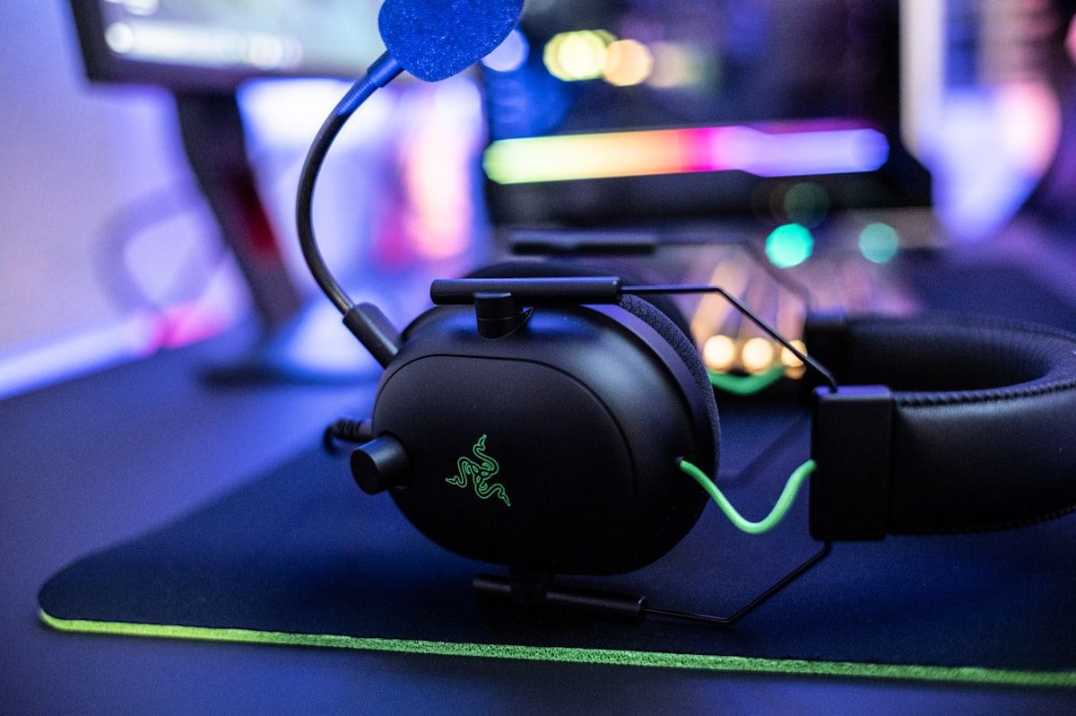 Headset gamer em destaque sobre mouse pad para jogos Close-up de um headset gamer sobre um mouse pad, ideal para jogos como LOL