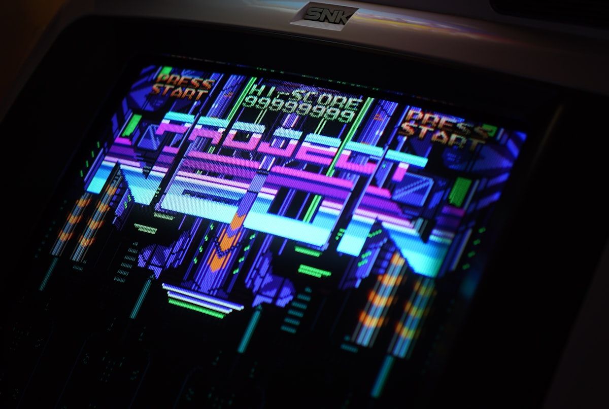 Máquina de arcade digital ligada no Fortnite Festival Close-up de uma máquina de arcade digital preta e cinza ligada, destacando os detalhes do jogo Fortnite