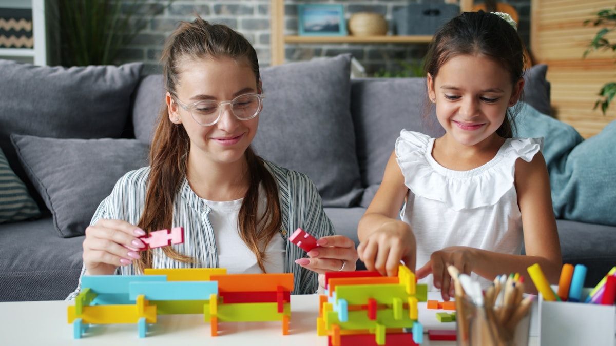 Mulher e criança brincando com blocos de construção coloridos Mulher e criança construindo com blocos coloridos, estimulando a criatividade e o aprendizado
