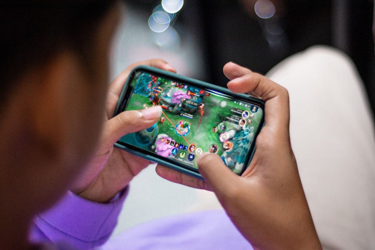 Pessoa segurando um celular jogando Fortnite Mobile em 2026