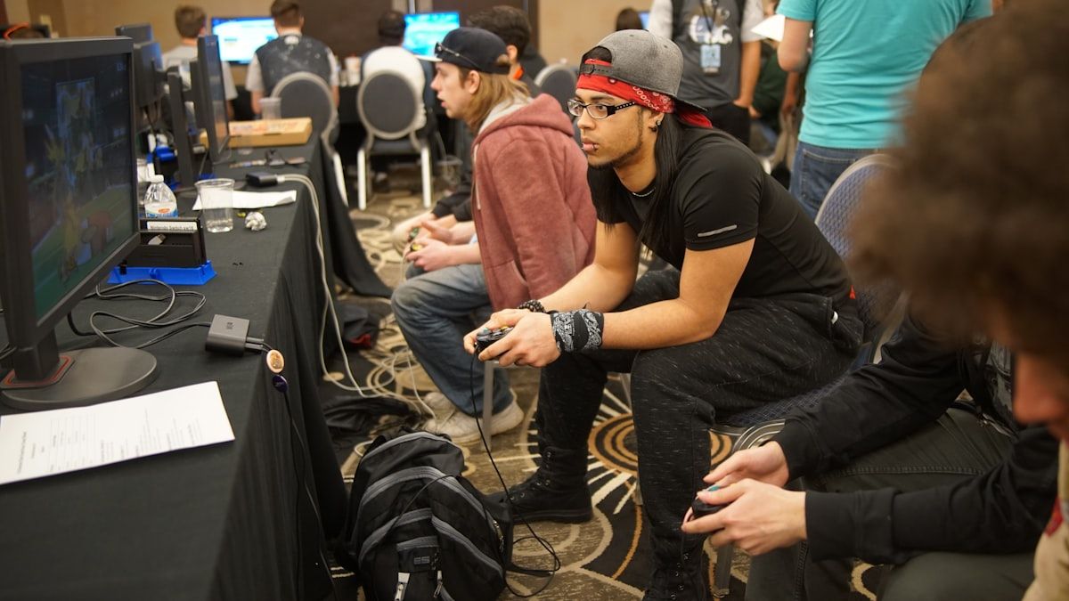 Homem jogando videogame em ambiente de esports Homem sentado em uma cadeira jogando videogame, imerso em competição de esports