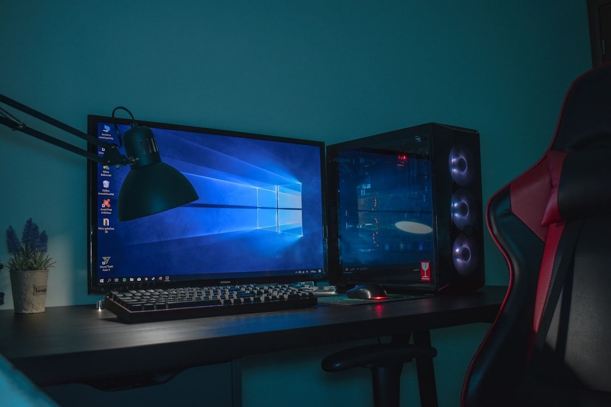 Desktop gamer e cadeira de couro para uma experiência imersiva Computador desktop ligado ao lado de uma cadeira gamer de couro preto e cinza, ideal para jogos