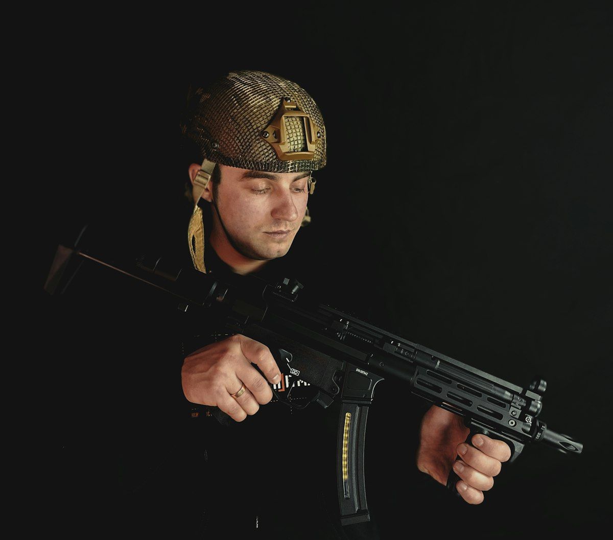 Homem com rifle e capacete em ação no CS2 Homem com capacete segurando um rifle, simbolizando táticas de jogos como CS2