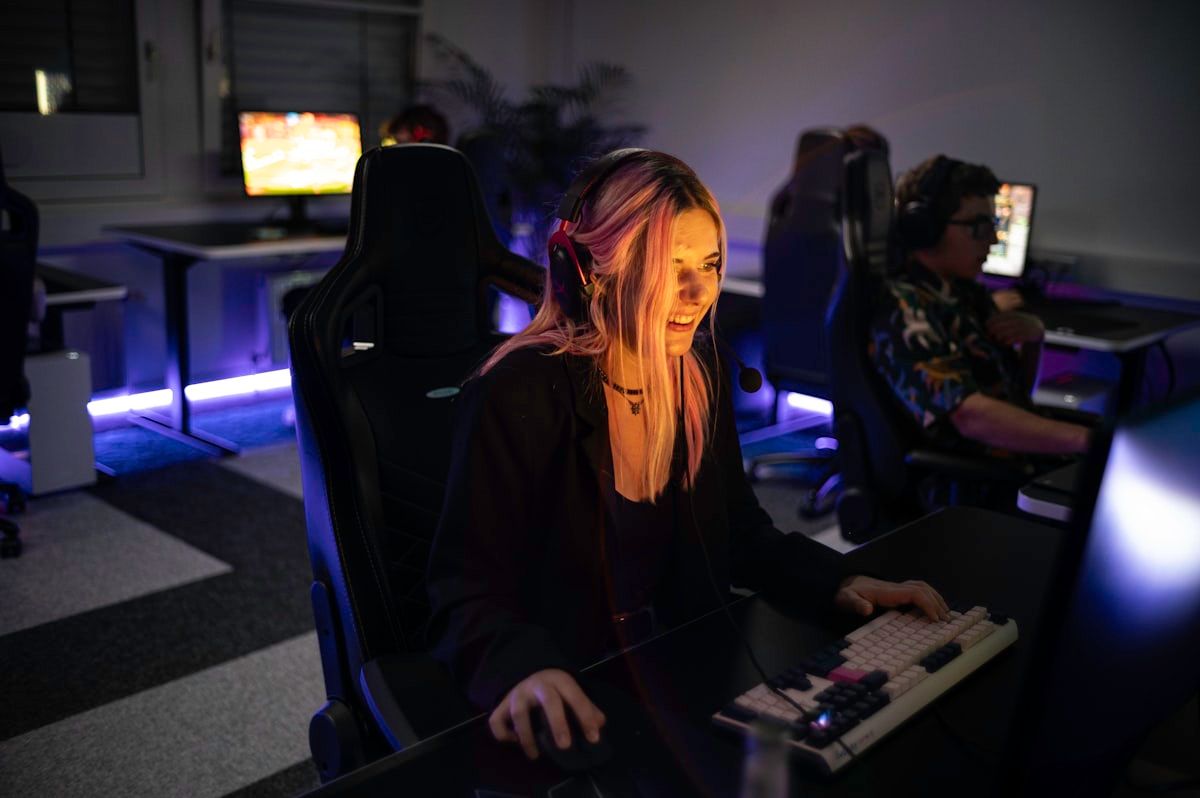 Ajustes de crosshair no CS2 por mulher em computador Mulher concentrada ajustando configurações de crosshair no CS2 em frente ao computador