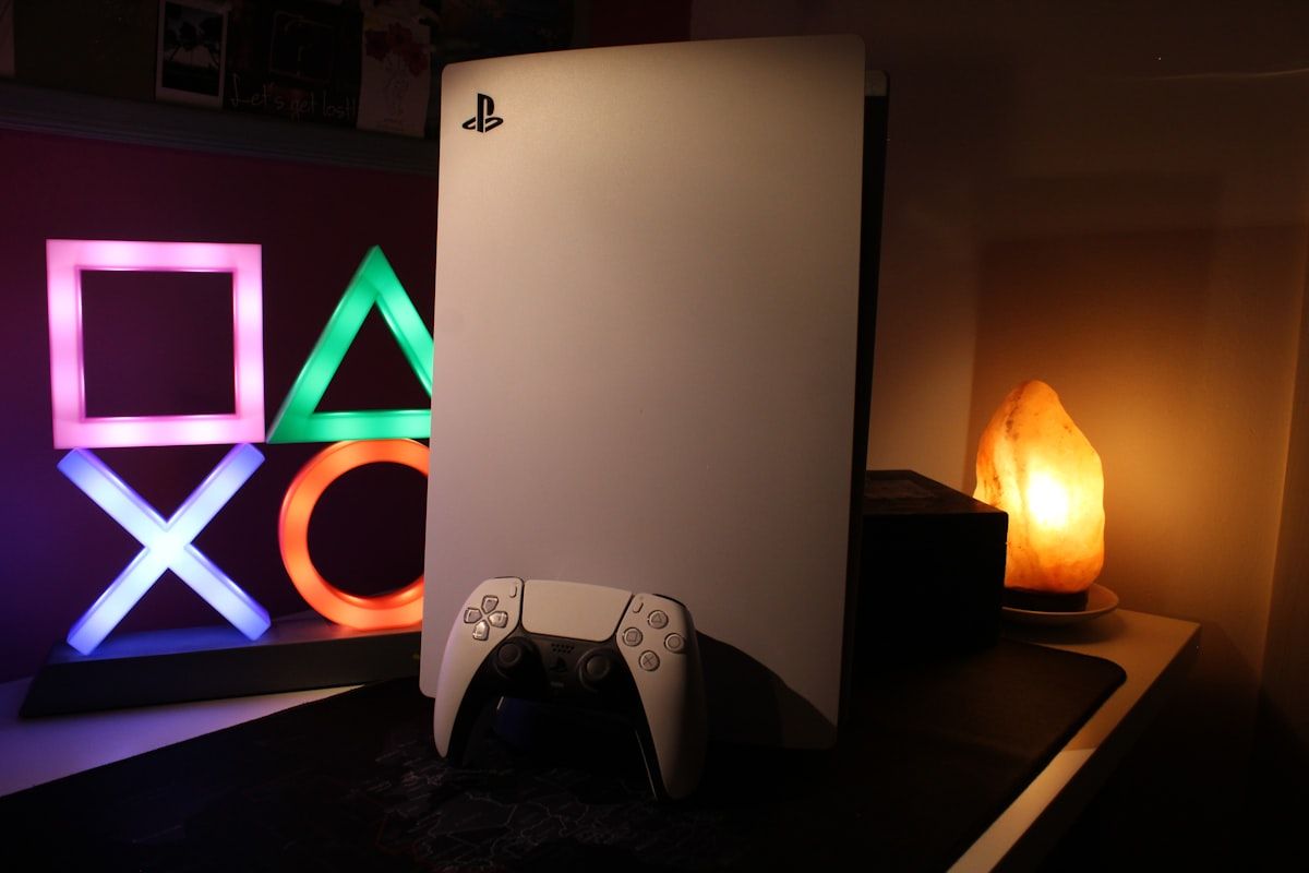 Console de videogame e sinal de neon em destaque Console de videogame ao lado de uma placa de neon iluminada, representando a nova geração de jogos